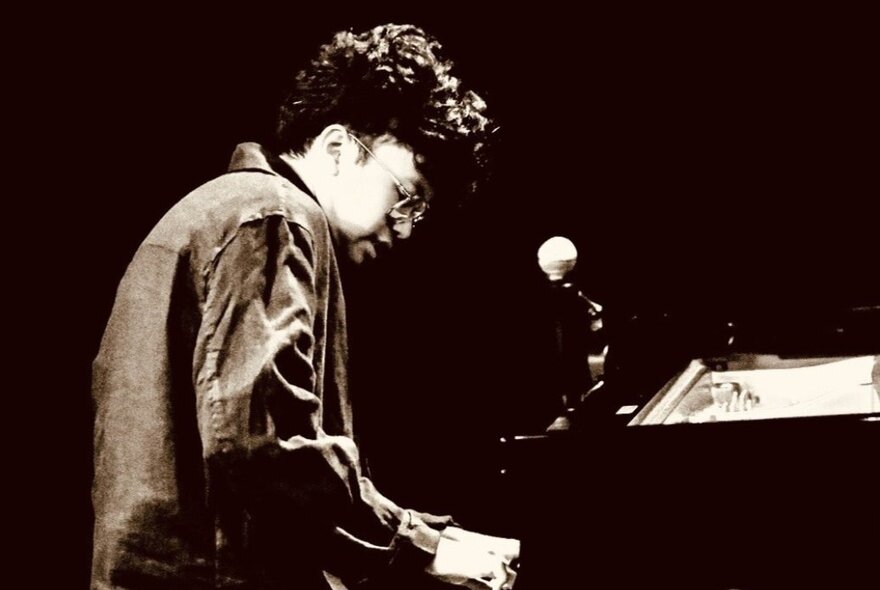 Young pianist at the piano and microphone.
