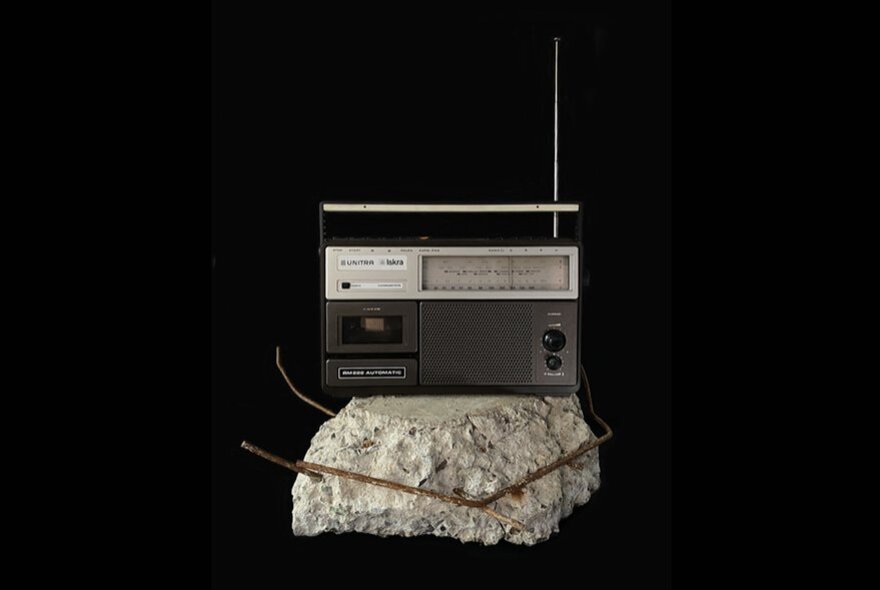 Artwork of a transistor radio on a cement block.