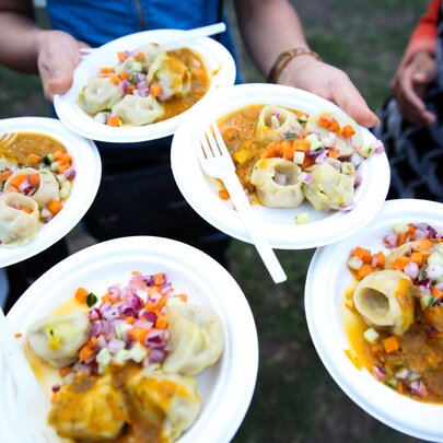 Looking down at 5 different plates of dumplings. 