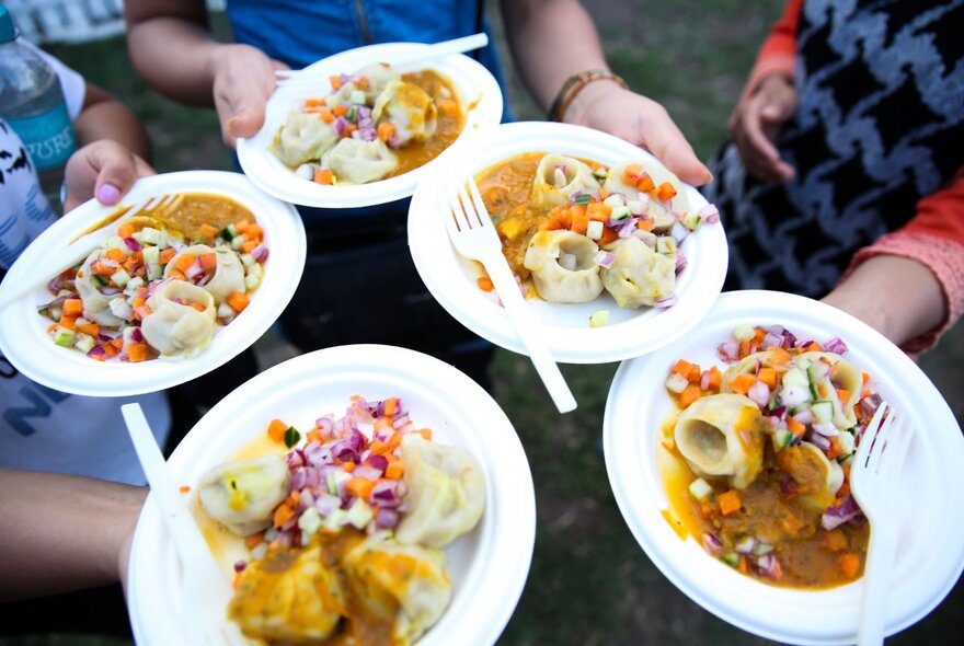 Looking down at 5 different plates of dumplings. 