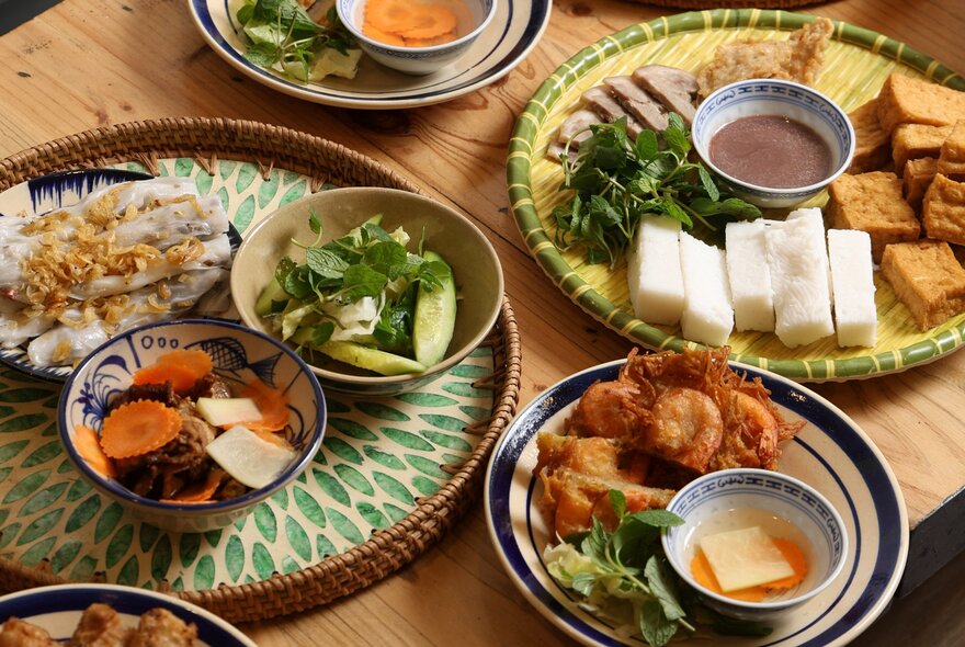 Small dishes of Vietnamese food on round trays.