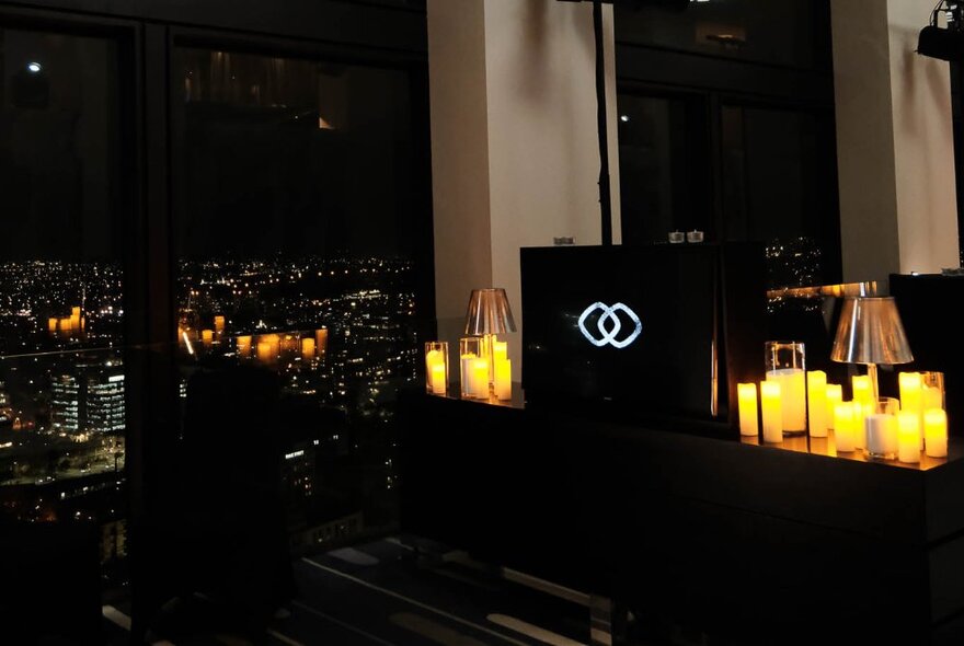 The dimly lit interior of Sofitel bar lounge area on level 35, with night views of the city from the floor to ceiling windows.