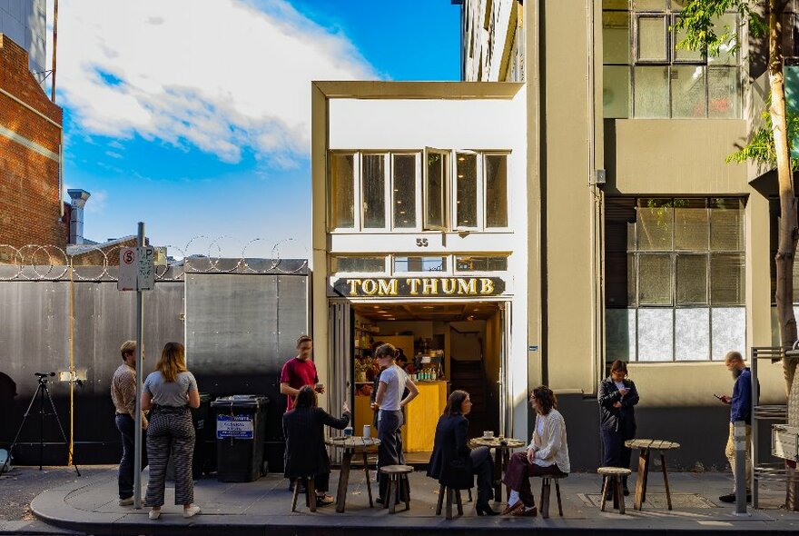 A group of people are in front of a laneway cafe