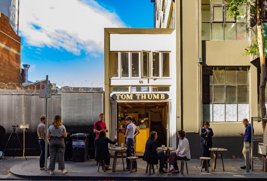 A group of people are in front of a laneway cafe