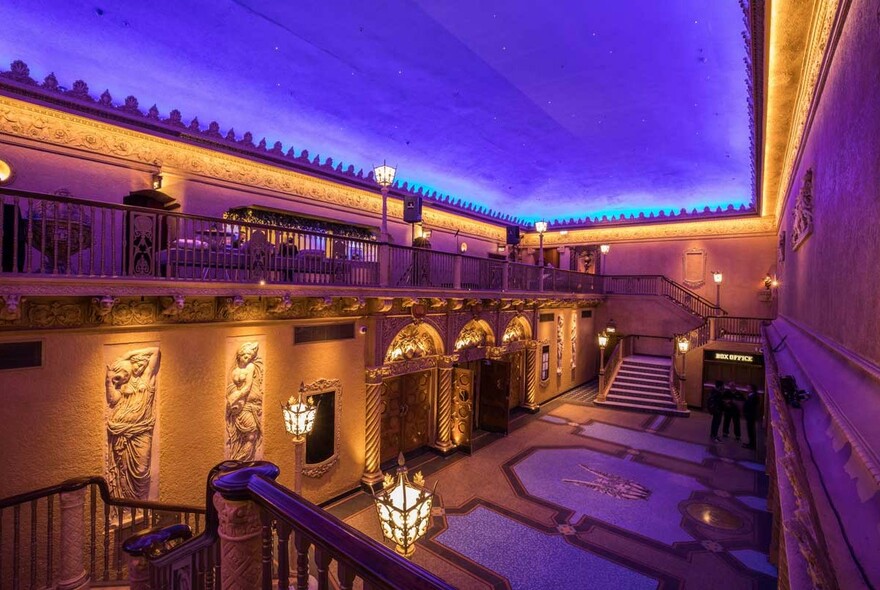 Inside historic Forum Melbourne, with statues and illuminated ceiling.