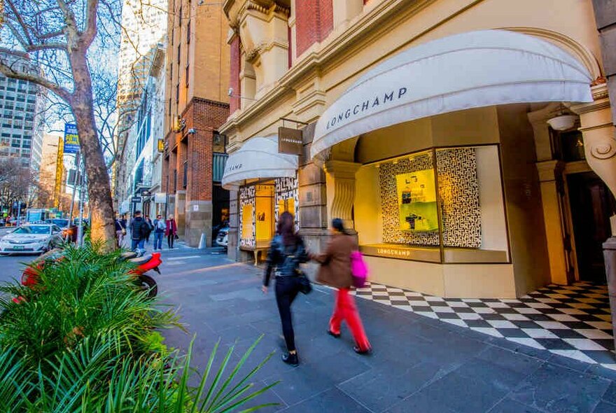 Women walking past a luxury store