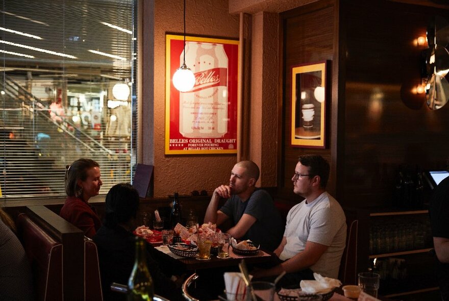 Four people sitting at a booth.