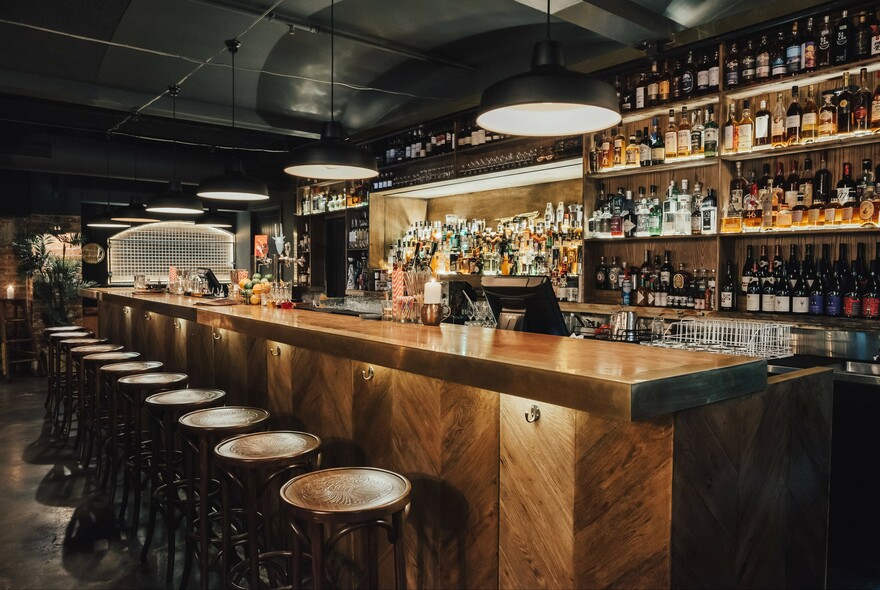 Bar stools lined up at a long bar.