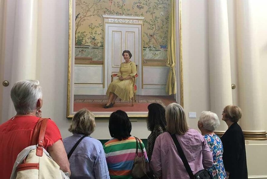 Tour participants gazing at a painting of Queen Elizabeth II.