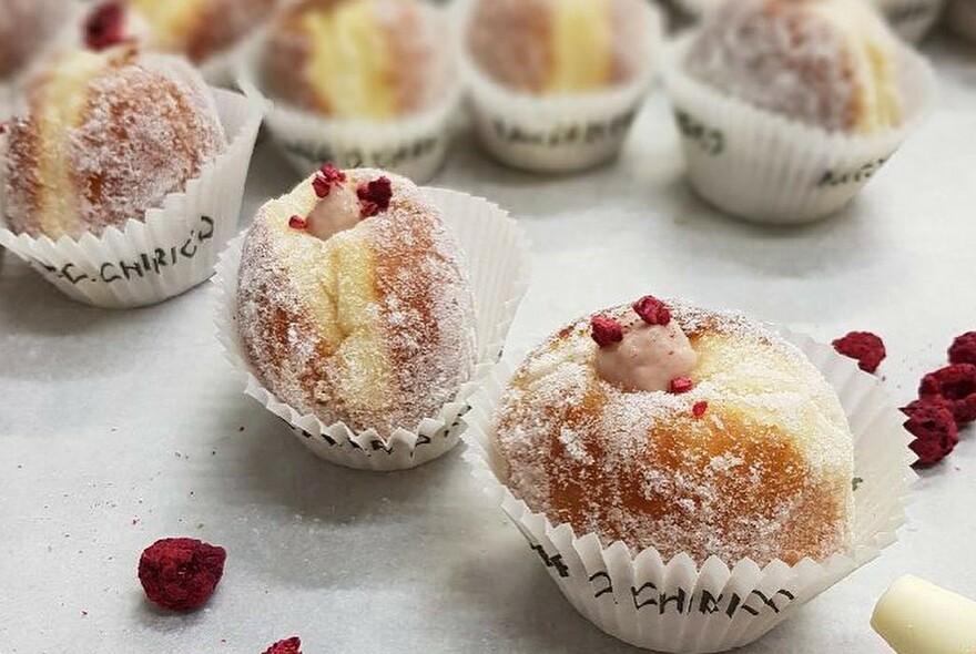 Several custard-filled Italian bomboloni sweet pastries. 