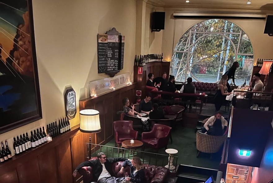 Looking down on the Kafeneion dining room showing tables and a large window.