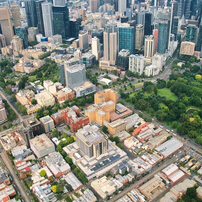 An aerial image of the city of Melbourne that shows blocks, the street grid, tall buildings, and parklands.