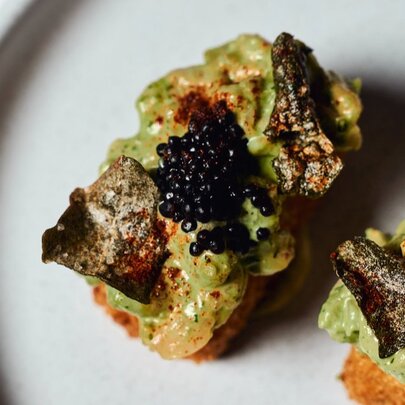 Avocado on toast with grilled garnish and caviar.