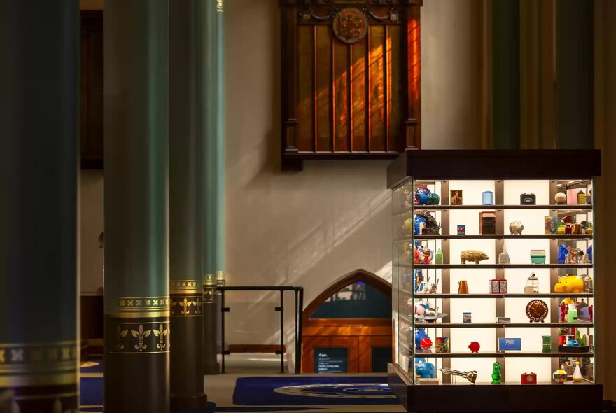 Interior of the ANZ Banking Museum, with artefacts from the bank's history and a display of colourful money boxes, within the restored heritage chamber.