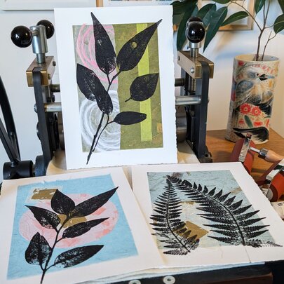 A table holding three different botanical prints on white card. 