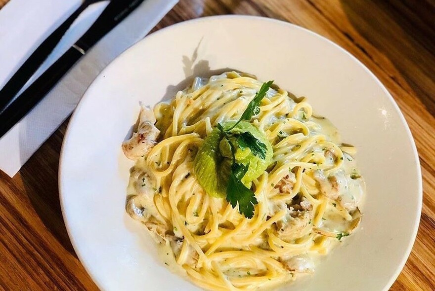 Plate of pasta with cutlery.