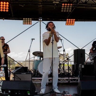 Afro-fusion artist Mikhaell performing live on stage with his band.