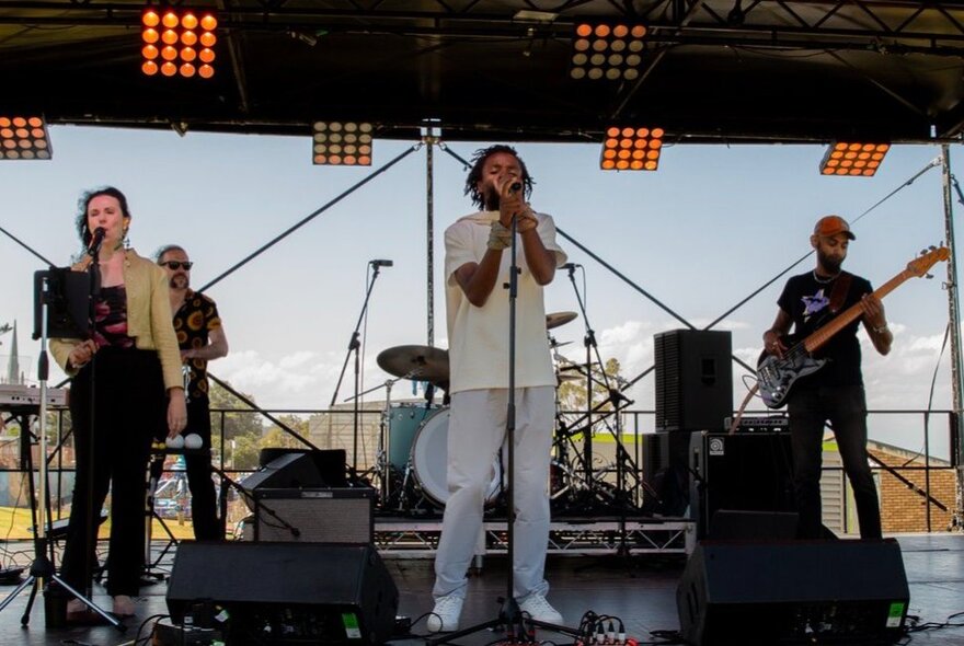 Afro-fusion artist Mikhaell performing live on stage with his band.