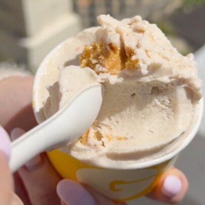 Hand holding spoon and cup of gelato.