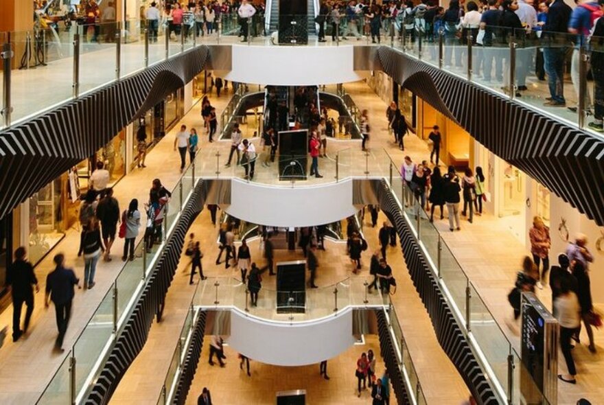 Three levels of Emporium Melbourne shopping centre, busy with shoppers