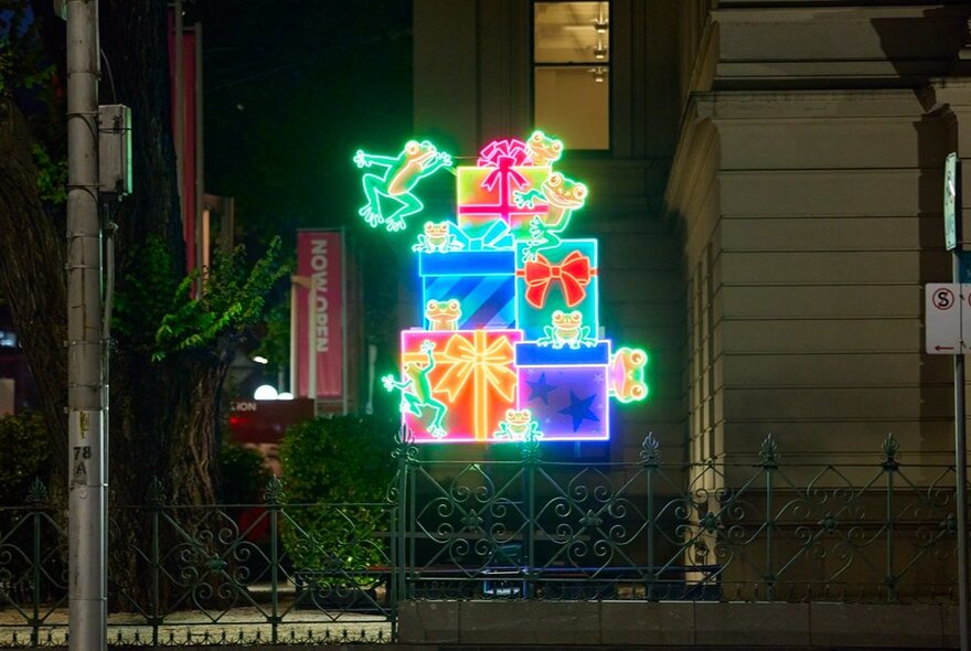 Light display of nine frogs on gifts. 