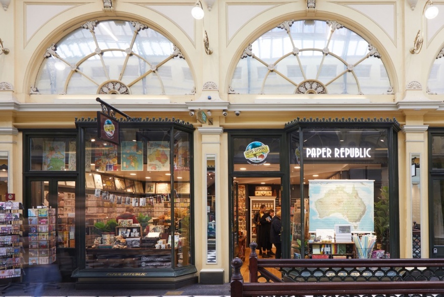 External view of shopfront in Royal Arcade with arched windows above doorway.