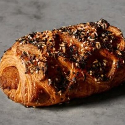 Latticed sausage roll on grey marble.