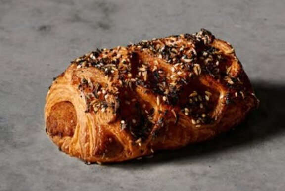 Latticed sausage roll on grey marble.