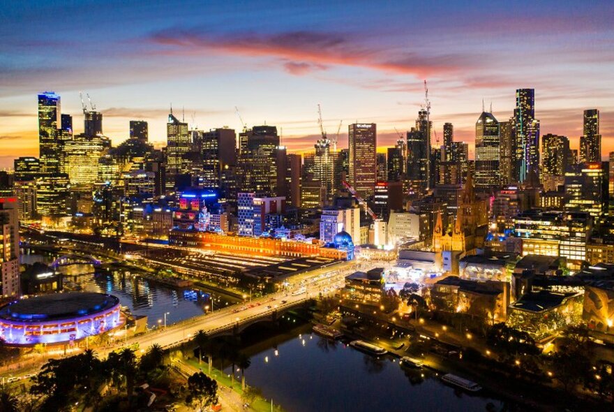 A view over Melbourne by night, with buildings lit up.