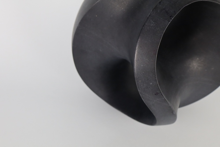 Smooth-textured, curved black abstract sculpture.