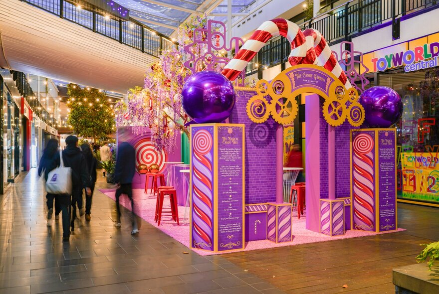 A festive installation at District Docklands, with shoppers walking past.