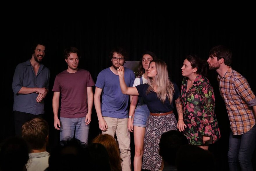 Ensemble cast on stage, improvising in front of an audience. 