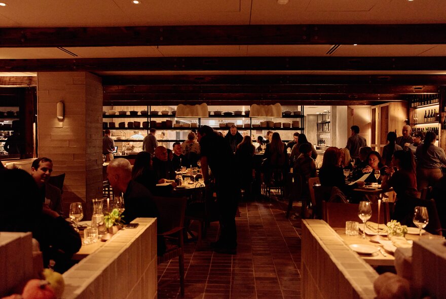 A brown-toned dining room full of patrons at tables. 