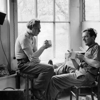 A black and white photograph of two artists sitting in a sunlit studio at the Abbey Art Centre, the iconic 1940s post-war artists' colony.