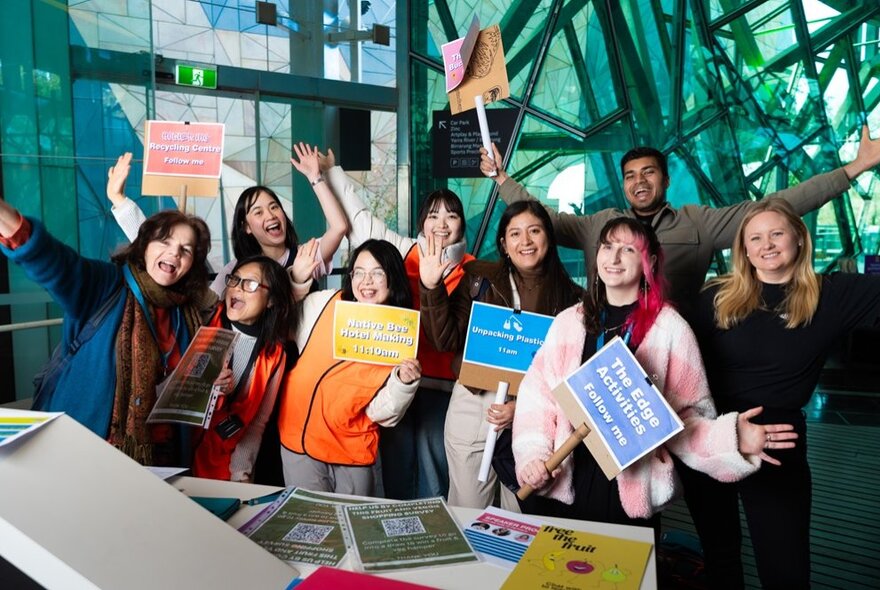 Presenters holding placards in the Atrium at Fed Square.