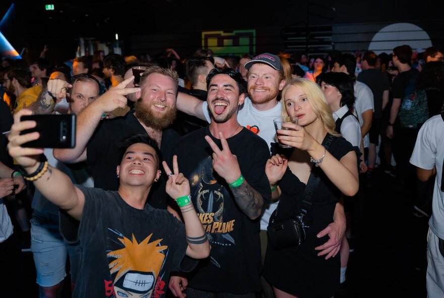 A group of five people taking a selfie in a nightclub.