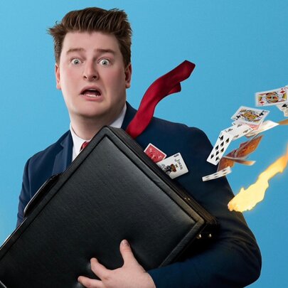 Comic magician holding a briefcase emitting a sparkling wand and playing cards.