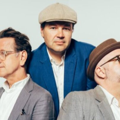Jake Mason Trio, three men wearing blazers, two with hats and glasses.