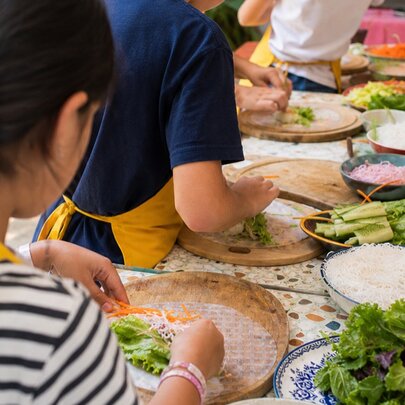 Children preparing Thai ingredients in a cooking class.