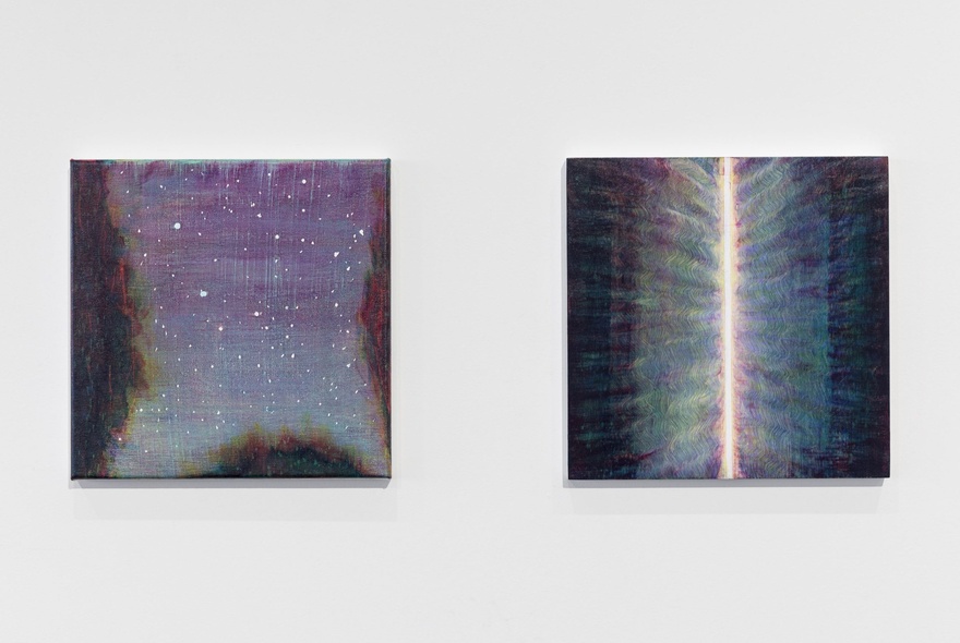A gallery wall with two artworks, one showing a starry night sky, the other with a central light shaft.