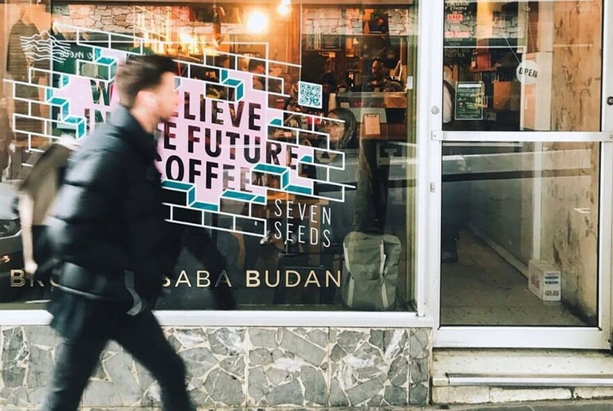 Person walking past Brother Baba Budan cafe window.