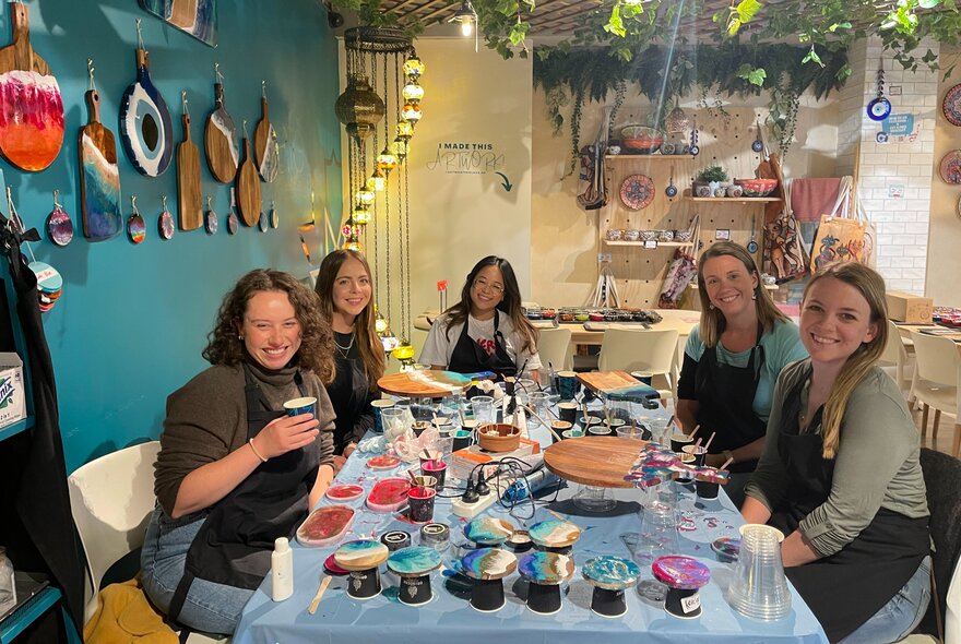 People seated around a crafts table in a studio.