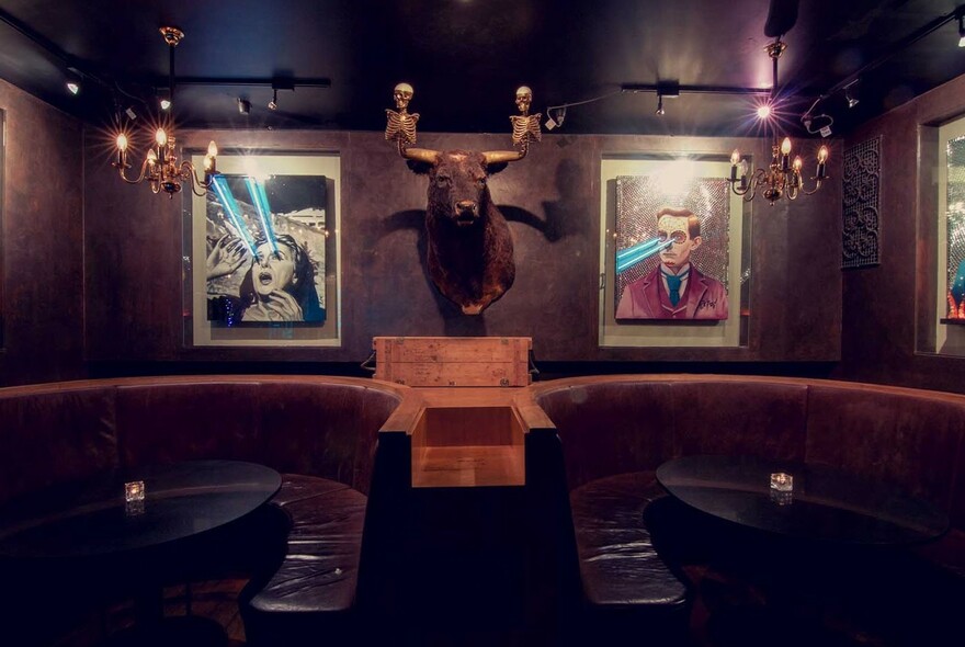 Interior of bar showing lounge booths with tables and wall decorations.