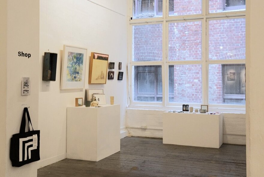 The gallery shop at fortyfivedonwnstairs, a small space with various artworks hanging on the walls and displayed on pedestals.