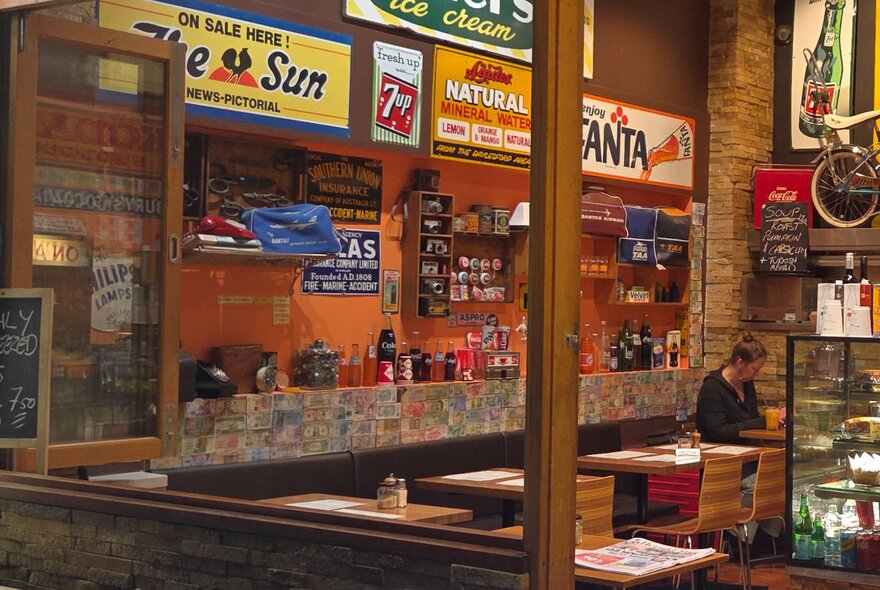 A restaurant with retro advertising signs on the wall.