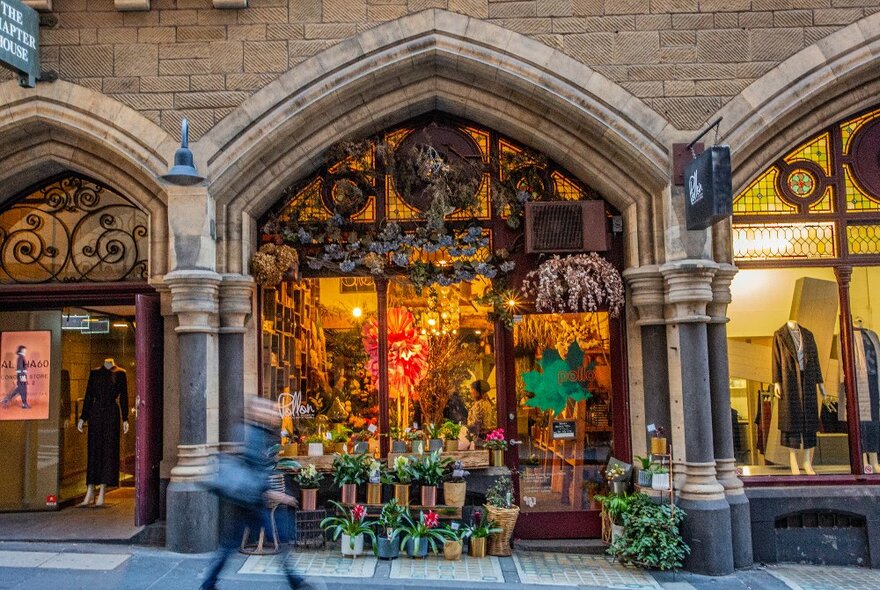 A person is walking in front of a florist.