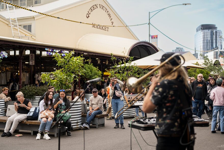 A musician playing the trombone at the Queen Victoria Market.