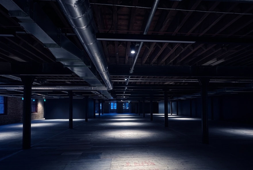 An empty warehouse space in the dark.