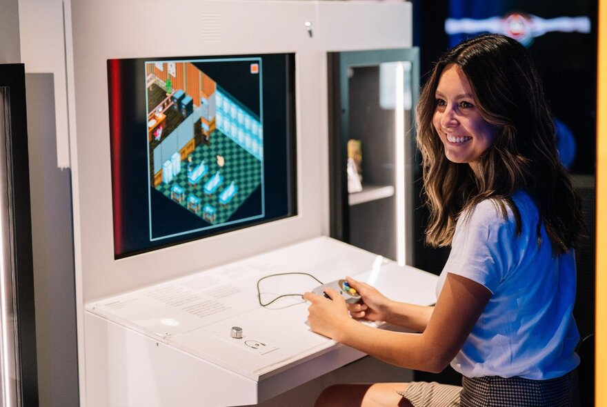A person holding a console in front of a games screen.