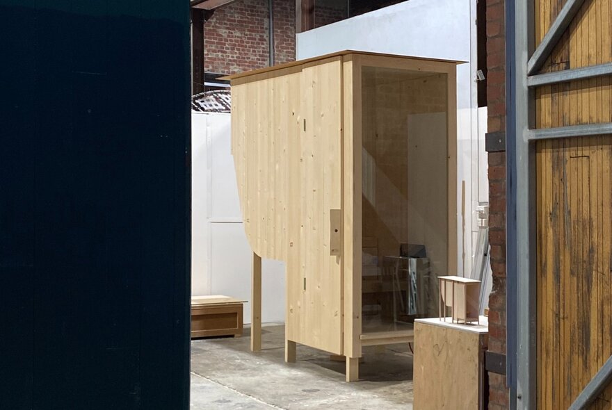 Looking through to a room with a pine sauna with glass door. 